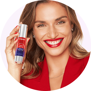 Leuke vrouw die glimlacht terwijl ze het serum in haar hand houdt.